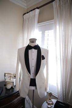 a tuxedo suit on display in front of a window