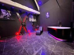 a bathroom with a black tub and red lights