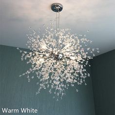 a chandelier hanging from the ceiling in a room with green walls and white clouds