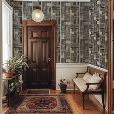 a room with a door, chair and rug on the floor in front of it