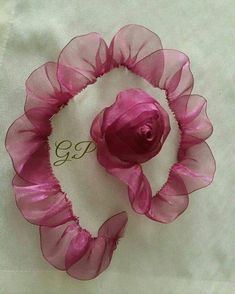 a pink flower on top of a white cloth with the word go written in gold