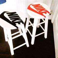 two stools with nike logos on them sitting next to each other in a room