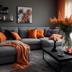 a living room filled with furniture and orange pillows