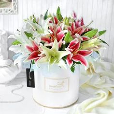 a bouquet of flowers in a white container on a table