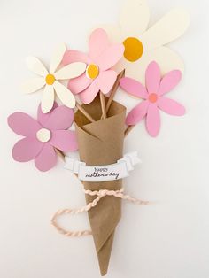 a bouquet of paper flowers is wrapped in brown paper