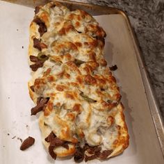 a pizza sitting on top of a pan covered in cheese and toppings with meat