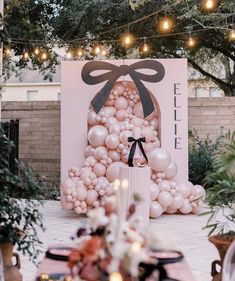 an outdoor event with balloons and lights on the trees, decorated in white and black