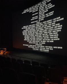 a large screen is projected on the wall in front of an empty theater auditorium with rows of seats