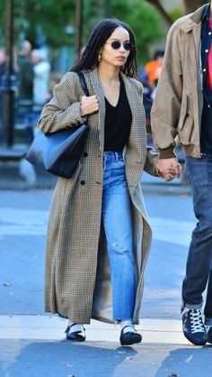 a man and woman walking down the street holding hands