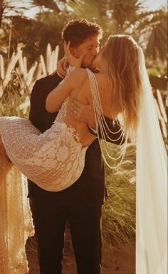 a man in a tuxedo is holding a woman on his back and she has her arm around him