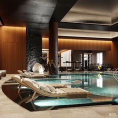 an indoor swimming pool with chaise lounges and gym equipment in the back ground