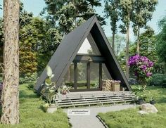 a - frame cabin in the middle of a grassy area with flowers and trees around it