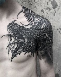 a man's chest with an intricate dragon tattoo on his left arm and chest