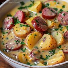 a white bowl filled with potatoes and sausage