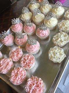 cupcakes with pink frosting and tiara decorations on a silver platter