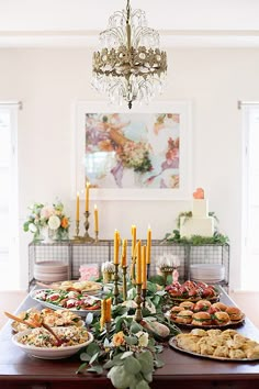 a table filled with lots of food on top of a white table covered in flowers