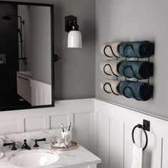 a bathroom with two towels hanging on the wall and a sink in front of it