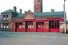 an old brick building with red doors and windows