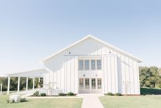 a large white barn with columns and windows