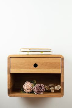 a wooden shelf with two flowers on it