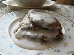 two pieces of food on a plate with a cup and saucer in the background