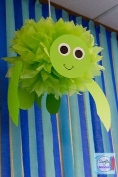 a green paper flower hanging from the ceiling