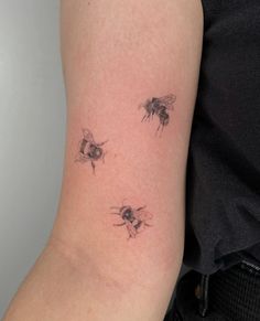 three bees tattoo on the right arm and left arm, with one bee in the middle