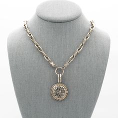 This vintage button necklace features a collectable vintage silver metal mirrored button with a delicate scroll design in the center and flower design on the ends securely attached to a large antiqued silver pendant displaying craftsmanship reminiscent of a bygone era. A vintage silver barbed wire style chain completes this vintage necklace with large lobster clasp For an effortlessly chic look wear this a one-of-a-kind silver statement necklace alone or layered with other jewelry or give this h Vintage Coin Necklace With Large Pendant, Vintage Metal Medallion Necklace With Coin Pendant, Vintage Metal Coin Necklace With Round Pendant, Silver Necklaces With Oval Pendant Vintage Charm, Silver Necklaces With Coin Pendant For Vintage Collection, Silver Necklace With Oval Pendant And Vintage Charm, Antique Silver Engraved Flower Pendant Necklace, Antique Silver Flower Pendant Necklace With Engravings, Vintage Medallion Coin Necklace With Large Pendant