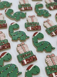 decorated cookies are arranged in the shape of christmas trees and dinos with presents on them