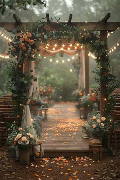 an outdoor wedding ceremony with flowers and greenery on the aisle, surrounded by string lights