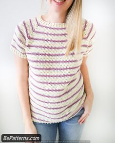 a woman is smiling while wearing a sweater