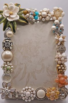 an ornate photo frame with flowers and pearls