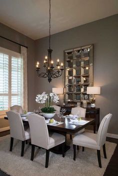 a dining room table with white chairs and chandelier