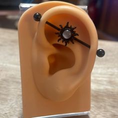 an ear with black beads on it sitting on a table