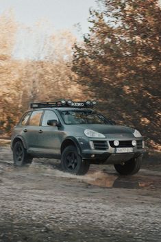 a grey car driving down a dirt road