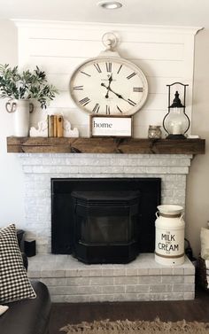 a living room with a fire place and clock on the wall above it's mantle