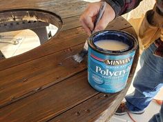 a person painting a wooden bench with a paintbrush