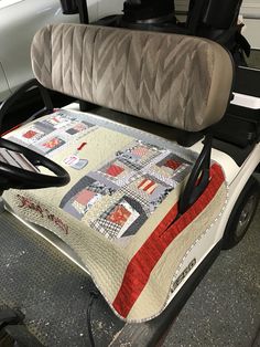 a golf cart seat with a quilt on it