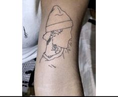 a man with a hat on his head has a small tattoo on his left arm