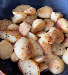 the potatoes are being cooked in a frying pan with seasoning on them,