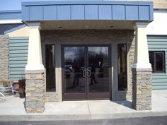 two people walking out the front door of a building