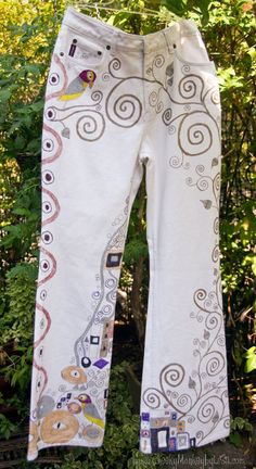 Inspired from the famous Austrian artist Gustav Klimt, the Doodled Denim images are hand drawn with fabric marker.  These Doodled Denims were so much fun to create, being a big fan of  Art Nouveau.   These pre-loved jeans were made by Nevada, have a Boot Cut cut leg and list a size of 10.  However, please review our own measurements and read the measurements information to ensure an accurate fit, as jean sizes vary greatly across designers.  These jeans have no stretch.  Measurements:  Waist=31i White Cotton Jeans With Graphic Print, Fitted Cotton Hippie Jeans, Artistic Cotton Bottoms With Graphic Print, White Embroidered Cotton Jeans, Artistic Cotton Jeans For Summer, Casual Hand Painted Cotton Bottoms, Artsy Cotton Jeans For Spring, Fashion Over 50 Fifty Not Frumpy, Fashion Preppy