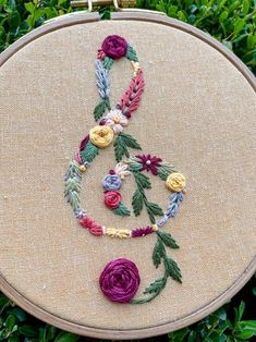 an embroidery project with flowers and leaves on it