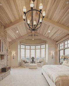 a bedroom with a large bed and lots of windows