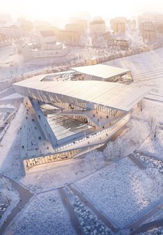 an aerial view of a large building in the middle of snow covered ground with buildings around it