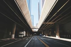 an empty street with cars and trucks on it in the middle of two large buildings