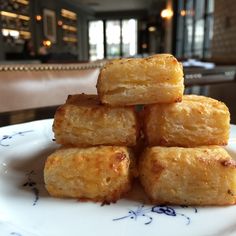 a stack of food sitting on top of a white plate next to a glass table