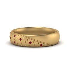 a gold wedding band with red stones on the outside and inside, in an oval shape