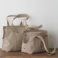 two canvas bags sitting on top of a wooden table