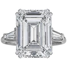 an emerald - cut diamond ring with baguets on the shoulders